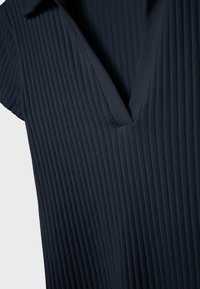 Indumento in tessuto a coste blu navy scuro con collo e scollo a fessura, mostrato in primo piano.