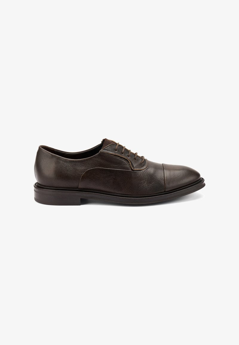 Scarpe stringate in pelle marrone con finitura liscia, punta rotonda e un sottile dettaglio cucito. Presentano una suola bassa e un design minimalista.