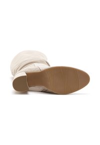 Beżowe zamszowe kozaki do kolan z elastyczną podeszwą, z teksturowaną gumową podeszwą i gładką powierzchnią górną.