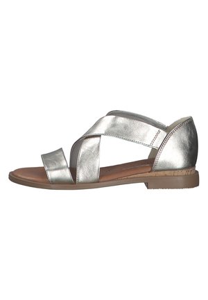 Sandal in argento metallico con due ampie cinghie incrociate e un pannello posteriore, caratterizzata da una suola piatta e un rivestimento interno testurizzato.