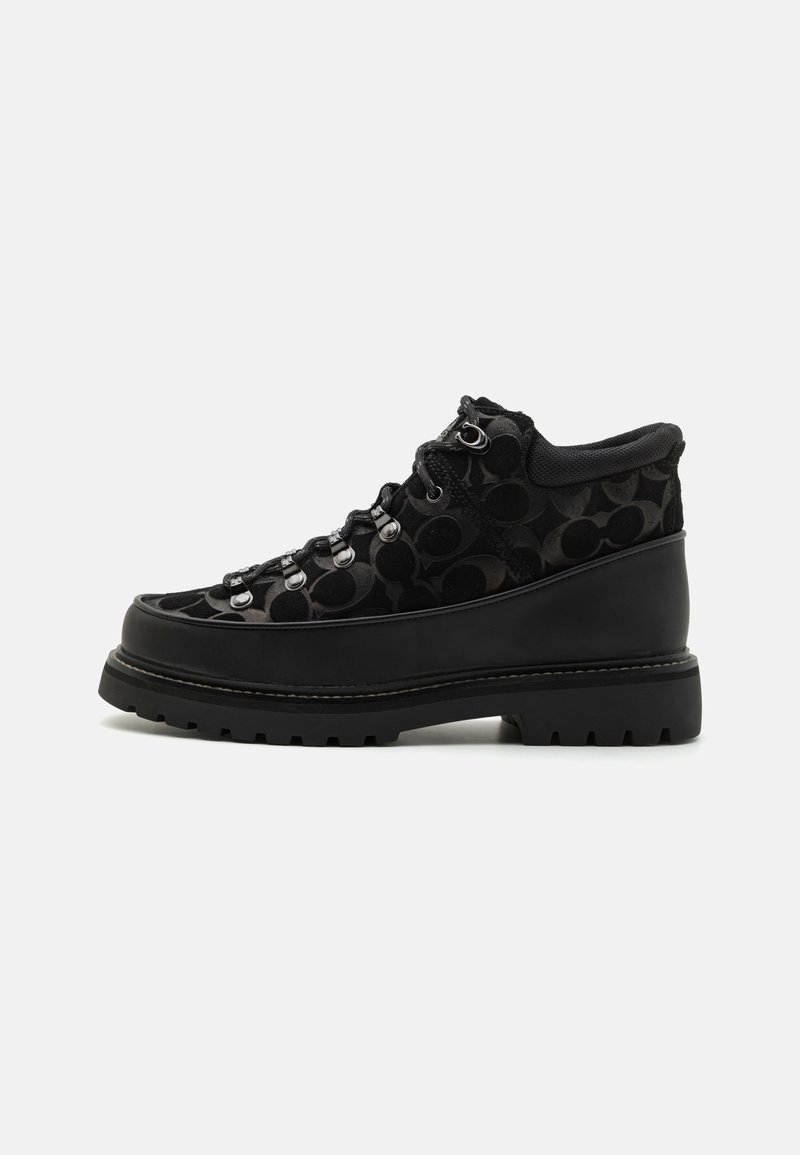 Schwarze Mid-Top-Schuhe mit einem strukturierten Samt-Obermaterial mit kreisförmigen Mustern, Schnürung an der Vorderseite, Metallbeschlägen und einer groben, profilierten Sohle.