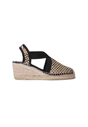 Vævet espadrille kilehæl med sorte elastiske stropper. Overdel i naturlig stråfarve med tekstureret mønster og flettet jutesål.