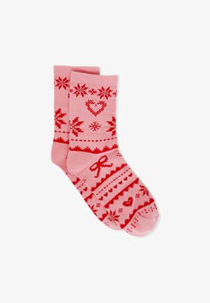 Calcetines rosas con patrones rojos de corazones, lazos y copos de nieve, con bandas decorativas y diseños geométricos en todo el tejido.