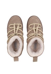 Botines de ante beige con forro de piel sintética color crema, gruesos cordones beige y una lengüeta de tirón en la parte trasera. Diseño de puntera redondeada.