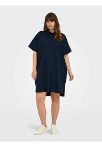 Rochie din cămașă de culoare albastru marin, cu guler, mâneci scurte și croi lejer. Prezintă slituri laterale și o textură netedă, moale.