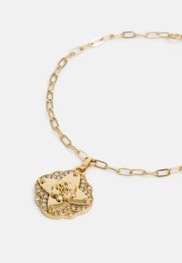 Gouden ketting met een stervormige hanger versierd met een bloemmotief en glinsterende rhinestones, aan een schakelkettinkje.