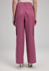 Hoge taille, loszittende cargobroek in een effen mauve kleur, met zijzakken en een gladde textuur. Achterzak zichtbaar.