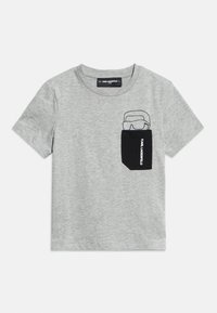 Tricou gri deschis cu mâneci scurte, guler rotund și buzunar negru pe piept cu un desen în linie al unei persoane care poartă ochelari de soare.