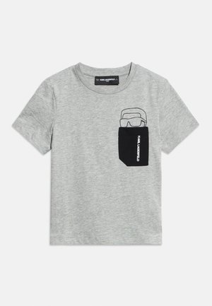 Světle šedé tričko s krátkými rukávy a kulatým výstřihem, s černou náprsní kapsou zdobenou liniovým kresleným motivem osoby s brýlemi na slunce.