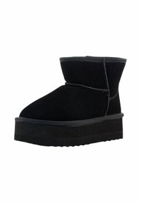 Stivaletto alla caviglia in suede nero con punta rotonda, cuciture minime e una spessa suola platform. Presenta una consistenza morbida e un design casual.