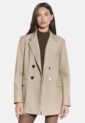 Beige dobbeltradet blazer lavet af tekstureret stof med sorte knapper, skarpe revers og sidelommer. Skræddersyet pasform med en afslappet silhuet.