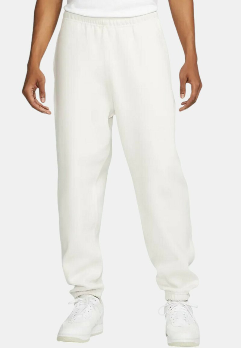 Weiße Jogginghose mit elastischem Bund, eng anliegenden Bündchen und Seitentaschen. Hergestellt aus einem weichen Stoff mit glatter Textur.