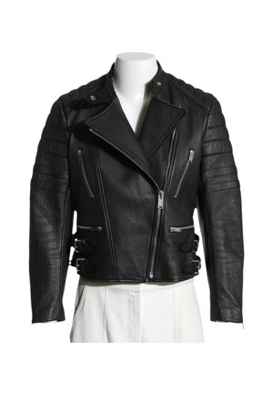 Veste de motard en cuir noir avec épaules matelassées, fermeture éclair diagonale, poches poitrine zippées et boucles latérales sur un torse de mannequin blanc.