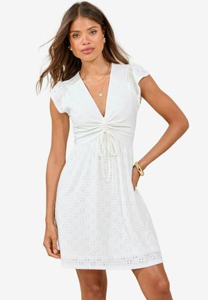 White cotton dress with short puff sleeves, deep V-neck, gathered front detail, drawstring waist, and eyelet pattern throughout.
