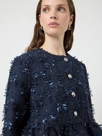 Μπλε σκούρο σακάκι με υφασμάτινη υφή, με κρόσσια και ασημένια κουμπιά, στρογγυλή λαιμόκοψη και ελαφρώς φαρδιά σιλουέτα.