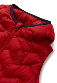 Gilet trapuntato rosso con zip frontale e rifiniture blu navy attorno al collo, dotato di logo ricamato sul petto.