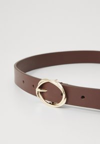 Brauner Ledergürtel mit glatter Textur, ausgestattet mit einer ovalen Schnalle in goldfarbener Optik und mehreren Einstelllöchern auf einer Seite.