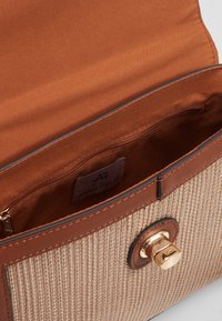 Borsa aperta intrecciata beige e marrone con chiusura a torsione dorata e tasca interna con zip etichettata Anna Field.