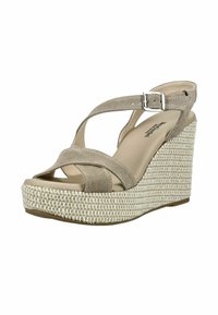 Sandale compensée en suède beige avec brides croisées, boucle argentée et semelle plateforme tissée.