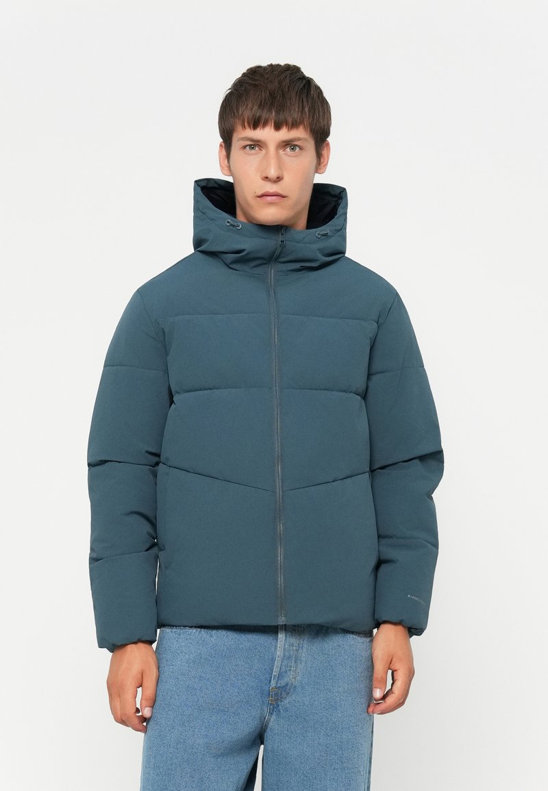 Padded hooded jacket in dark teal, featuring a zip front, elastic cuffs, and contrasting black lining, with a quilted design for warmth.