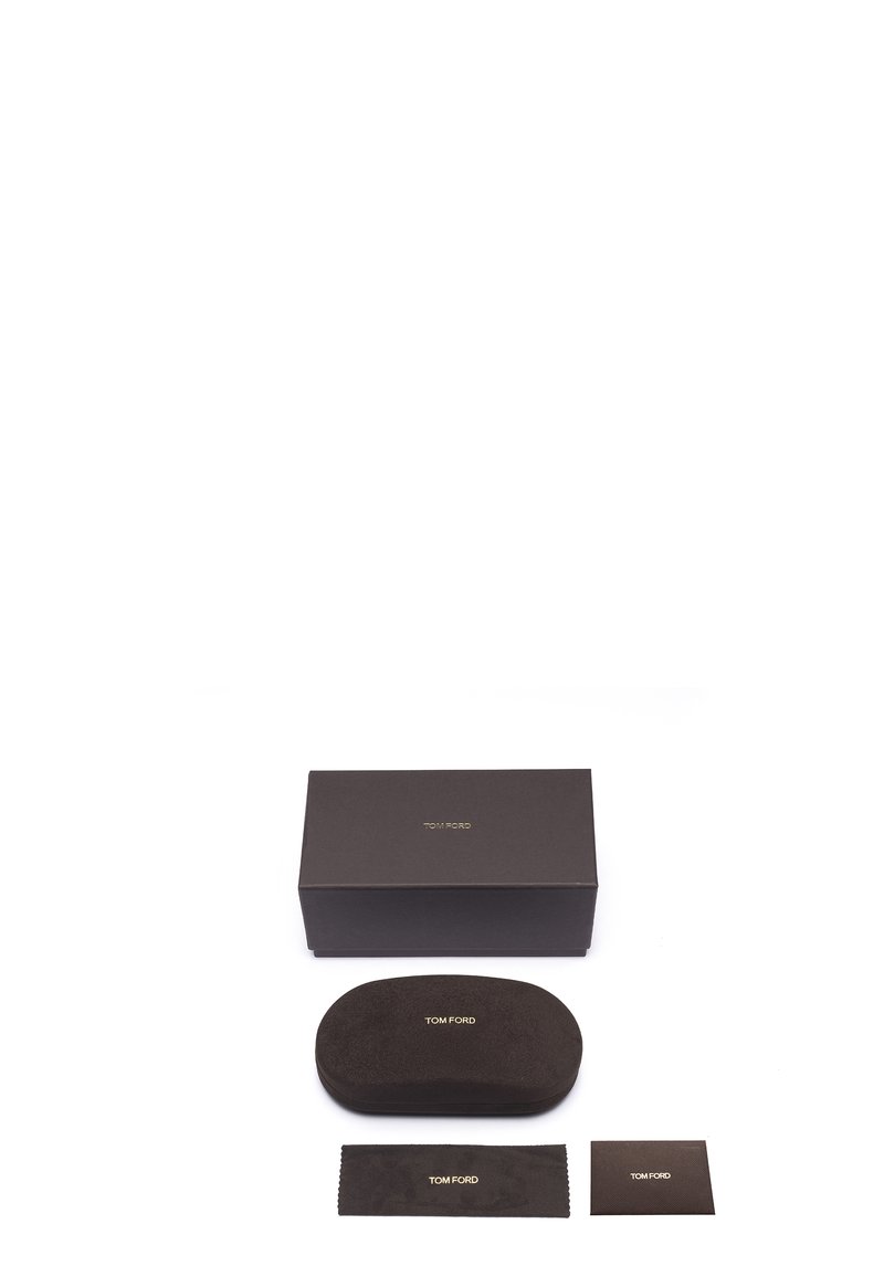 Brown packaging with gold "TOM FORD" branding. Includes a matching oval case, cleaning cloth, and care card, all in a similar color scheme.