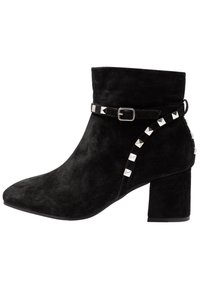 Stivale alla caviglia in suede nero con tacco a blocco, punta appuntita e una cintura con borchie a piramide argentate lungo il lato per dettagli.