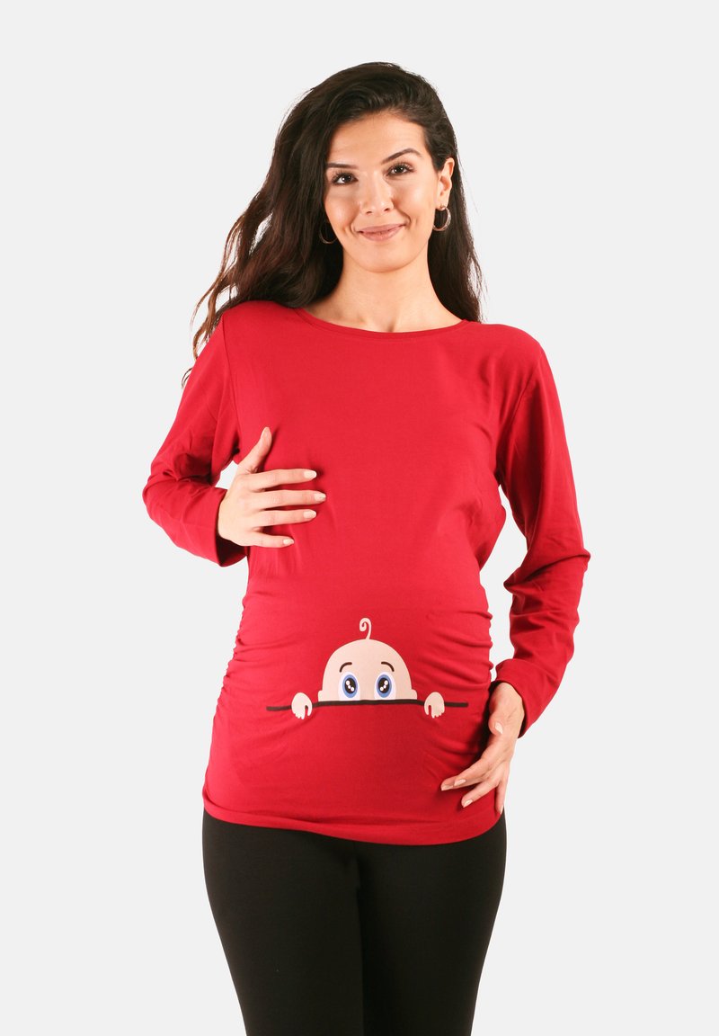 Rotes langärmeliges Stillshirt mit dehnbaren Seitennähten. Mit einem Cartoon-Baby-Design, das unten herausblickt. Aus weichem, atmungsaktivem Stoff.