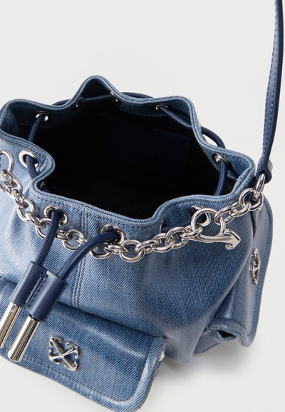 Μπλε τζιν τσάντα τύπου μπαρέτα με αλυσίδα από ασημί για κορδόνι σύσφιξης, δερμάτινες λεπτομέρειες και ανοιχτό πάνω μέρος που δείχνει άδειο εσωτερικό.