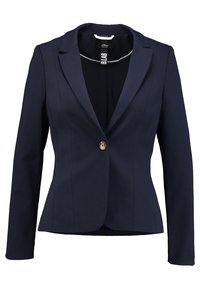 Granatowa marynarka z pojedynczym złotym guzikiem, dopasowany krój, klapy w kształcie litery notch oraz widocznymi szwami. Gładki materiał z wyraźną sylwetką.