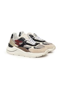 Beige en zwarte gestructureerde sneakers met leren, mesh en suede accenten. Heeft een dikke witte zool en contrasterende rode designelementen.
