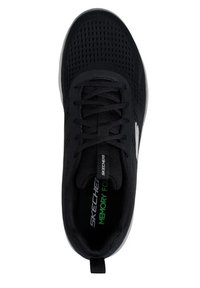 Scarpa sportiva nera con tomaia texture, colletto imbottito e suola flessibile; presenta marchi verdi e bianchi sulla soletta e sul lato.