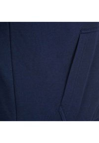 Námořnická modrá textilie s texturovaným povrchem, vybavená boční kapsou a čistým šitím pro moderní design.