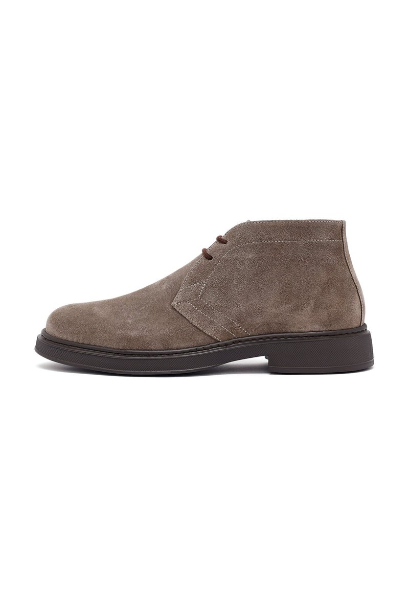 Botas de ante taupe para hombres, con suela de goma marrón oscuro y cierre de cordones de dos ojales, mostradas desde el lado exterior.