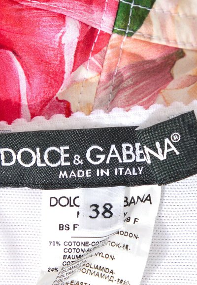 Étiquette de vêtement montrant la marque Dolce & Gabbana, taille 38, avec un tissu fleuri et des détails de composition du matériau en plusieurs langues.