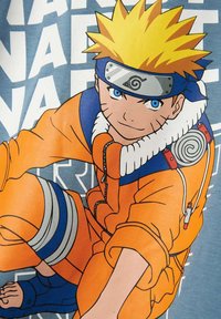 Sweat à capuche orange présentant un personnage de dessin animé avec des cheveux blonds en pics et des yeux bleus, entouré de texte blanc sur un fond bleu clair.