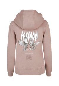 Růžová mikina s velkým grafickým vyobrazením dvou bílých holubic. Slovo "SVOBODA" je výrazně zobrazeno ve stylizovaném písmu nad tímto designem.