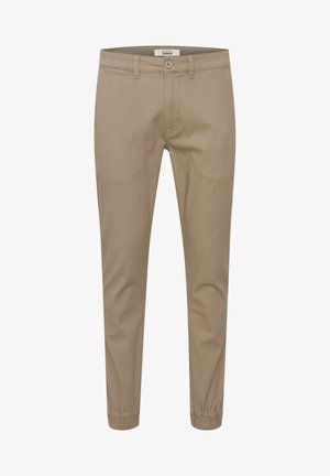Pantalones beige de corte ajustado, hechos de una suave mezcla de algodón. Cuentan con puños elásticos, bolsillos frontales y un clásico cierre de botón.