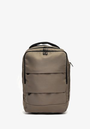 Zaino rettangolare color taupe con multiple tasche zip, con tiranti neri e manico superiore imbottito su sfondo bianco.