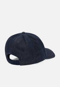 Casquette de baseball en denim bleu foncé avec une sangle arrière ajustable élastique, un design à six panneaux et un bouton rond sur le dessus, vue de dos sur fond blanc.