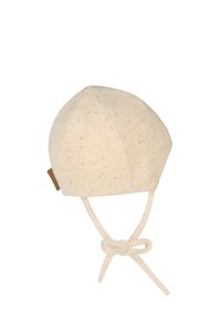 Beige knit baby bonnet with small brown speckles and tied chin straps on a white background.