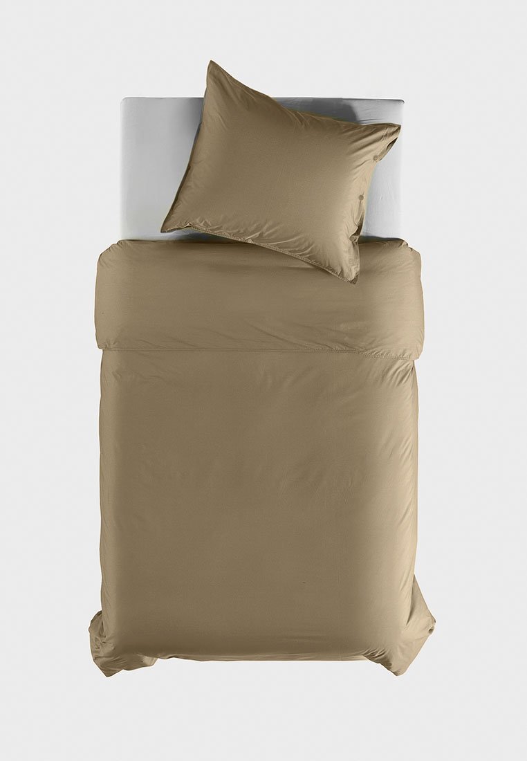 Beiges Bettbezug-Set mit glatter Textur, einschließlich eines passenden Kissenbezugs und auf einer weißen Matratze angeordnet. Einfaches, modernes Design.