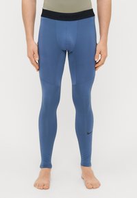 Ναϊκή μπλε κολάν Pro με υφασμάτινο μαύρο ελαστικό λαιμό, εφαρμοστή σχεδίαση, λείο ύφασμα και διακριτές ραφές.