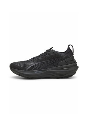 Chaussure de course noire avec une tige en mesh texturé, une semelle en mousse épaisse et de subtils accents réfléchissants. Caractéristiques : design à lacets et onglet de traction à l'arrière.