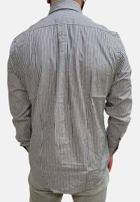 Camicia a righe da uomo in cotone. Presenta sottili righe verticali in colori scuri e chiari, maniche lunghe e colletto.