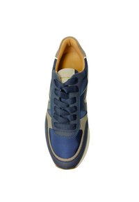 Herren Sneaker in Marineblau, der eine Kombination aus glatten und strukturierten Materialien aufweist, auffällige Schnürsenkel und einen kontrastierenden grauen Rand entlang der Seiten.