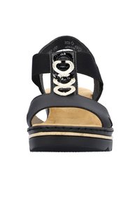 Sandal nera con punta aperta, dotata di una parte superiore liscia, cinturino elastico e decorazioni circolari in beige e nero lucido.