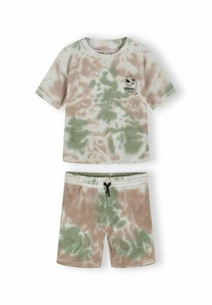 Ensemble chemise à manches courtes et short tie-dye vert et beige, avec un petit motif graphique noir sur la poitrine de la chemise.