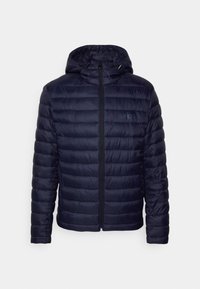 Marinblå puffjacka med horisontellt kviltat mönster, fast huva, hel dragkedja och lätt glans; har logotyp på bröstet.