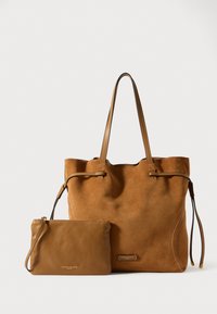 Geantă tote din suede bej, cu mânere din piele și închidere cu șnur, însoțită de un mic pouch din piele asortat. Ambele au un branding minim.