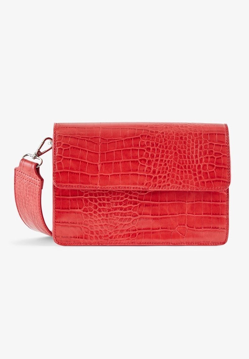 Sac bandoulière rectangulaire rouge à texture crocodile avec une sangle amovible équipée d'une boucle métallique sur fond blanc.